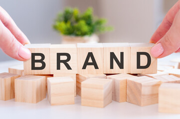 Close-up of person hand holding the word brand on wood blocks
