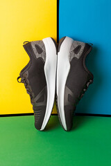 
Concepto de calzado deportivo negro sobre un fondo amarillo y azul