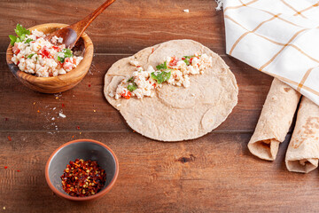 Sikma is a traditional Turkish wrap in mediterranean coast of silifke, mersin. Flat bread known as bazlama is laid and filled with mixture of cheese, tomato and herbs and rolled around tightly.