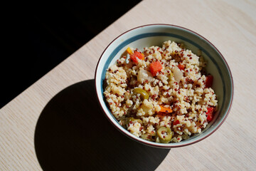 Italian quinoa salad with a bell pepper, green olives, tomatoes - vegetarian, vegan food, minimalist dish, shadow, Japanese bowl