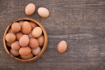Bowl of fresh farm eggs on wooden background