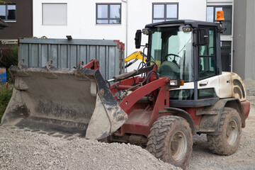 Kleiner Bulldozer baggert Kies auf einer Baustelle