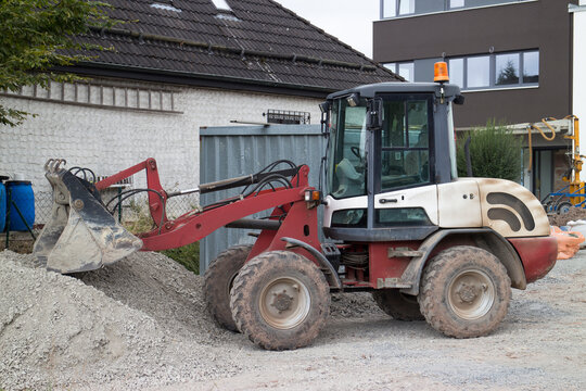 Kleiner Bulldozer baggert Kies auf einer Baustelle