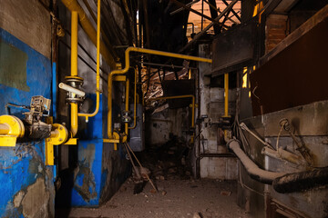 Fototapeta na wymiar Inside old collapsed industrial building. Old rusty pipeline
