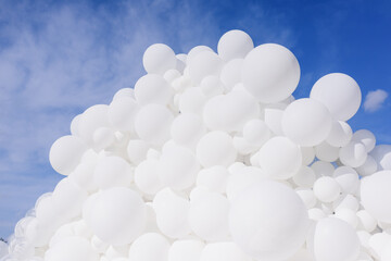 Close up view of a lot of white balloons on the sky background.