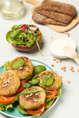 Rye bread sandwiches with falafel, tomatoes and green salad. Vertical frame, close-up, selective focus