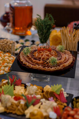 Close up of serving table with a variety of sliced meat  food on the banquet.