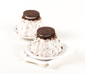 Panna cotta with chocolate vanilla cookies on a plate on a white background