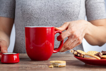a tea time or coffee time concept with sandwich cookies, bars of chocolate aesthetic ceramic mug...