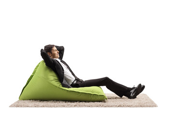Businessman relaxing on a green bean bag chair