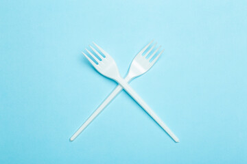 Plastic forks on a blue background. Plastic waste and pollution concept
