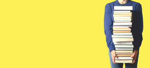 Student with books on a blank colored banner background. Education, reading and study background concept