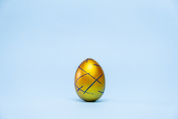 Happy Easter. One easter egg trendy colored classic blue, white and golden on blue background. Copy...