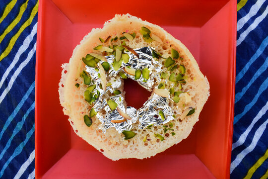 Traditional Indian festival dessert sweet Ghewar. unique different from India rajasthan eated during festivals like holi. with decorative background