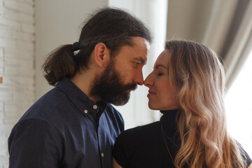 Man embracing pregnant partner in kitchen.