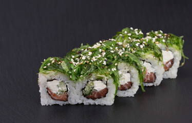 Sushi Rolls Green Roll with RICE, CREAM CHEESE, CUCUMBER, SALMON, WAKAME AND SEZAM.
