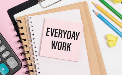 EVERYDAY WORK text on the notebook with pen, clips and glasses