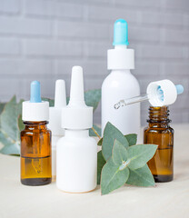 different tubes with drops for the nose and a sprig of eucalyptus