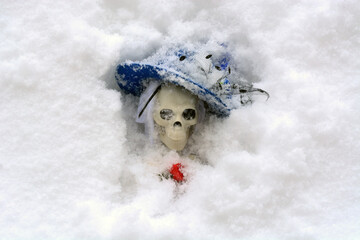 Woman skeleton in fancy blue hat buried in snow during storm blizzard