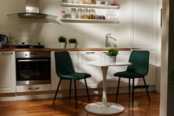 Modern Scandinavian kitchen interior with table and chairs.