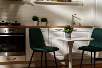 Modern Scandinavian kitchen interior with table and chairs.