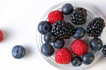 blueberries, raspberries and blackberries on white background