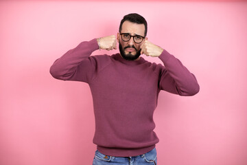 Handsome man wearing glasses and casual clothes over pink background depressed and worry for distress, crying angry and afraid. Sad expression.