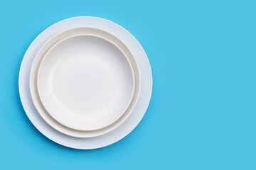 Stack of dishes on blue background.