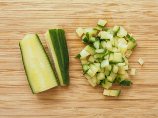 Cucumber cutted in half and in dices over a wood table
