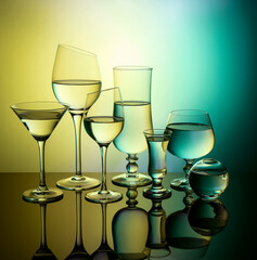 Glass goblets on colored gradient background