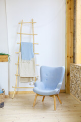 Scandinavian room with blue and white colors. Blue armchair in a white room. Armchair with fabric upholstery
