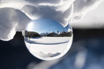 View of a scenic snow peaked mountain range in a lens ball on a sunny day.