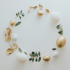 Flat Lay of Golden Easter Eggs ring circle on white background. Easter background or easter concept. Still life, pastel toned