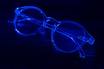 Fototapeta na wymiar Eyeglasses on the office table on the dark background