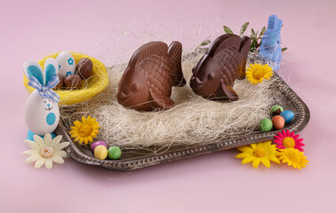 Vintage tray with milk and dark chocolate fish on a nest with eggs