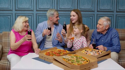 Happy multigenerational family having lunch party at home, eating pizza food, raising toast together