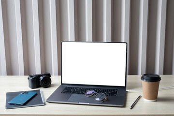 Special workspace: phone, camera, laptop, coffee, laptop and paper on a wooden bakcground.