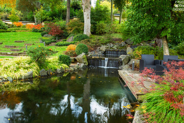 Fototapeta na wymiar Cascade of small waterfalls in japanese garden of Kaiserslautern - idyllic autumn