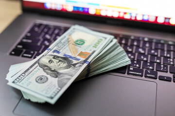 Dollars hundred banknotes on a laptop keyboard