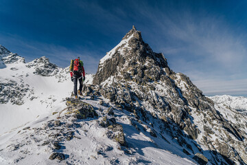 An alpinist climbing in winter alpine like landscape of High Tatras, Slovakia. Winter...