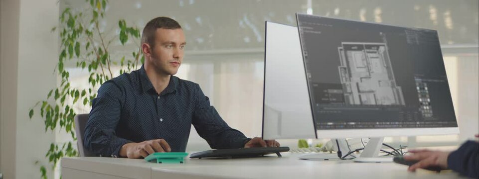 Young Architect modeling a new apartment in 3D software in a modern office.
