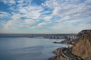 beautiful sunrise on the beach with rocks and clouds, located in Alicante, Spain.
