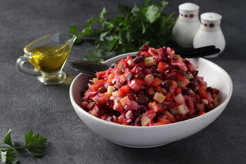 Traditional salad Vinaigrette of beets, potatoes, carrots, beans, pickles, onions and vegetable oil on dark gray background. Vegetarian food