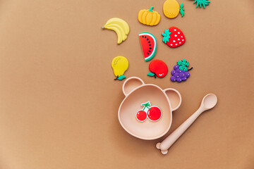 Bright silicone dishware on light background. Serving baby, first feeding concept. Flat lay, copy space, top view