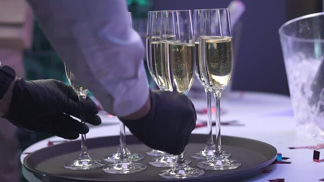 The Waiter Puts Glasses Of Champagne On A Tray At A Wedding Party