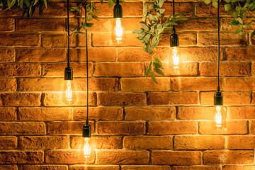 Decorative incandescent bulbs in Edison style on a brick wall background