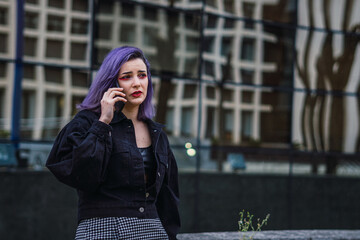 Young woman with purple hair talking on cell phone