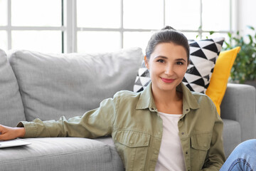 Young woman near sofa at home