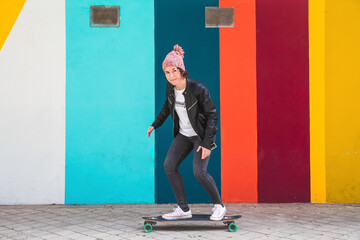 brunette woman with cap and skateboard on colorful background