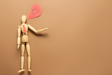 Wooden mannequin and speech bubble with text APRIL FOOL'S on color background